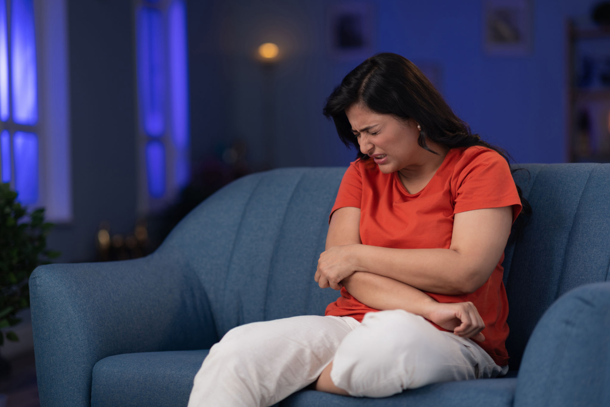 donna over 40 stanca la sera con mano sulla pancia per cortisolo e digestione lenta