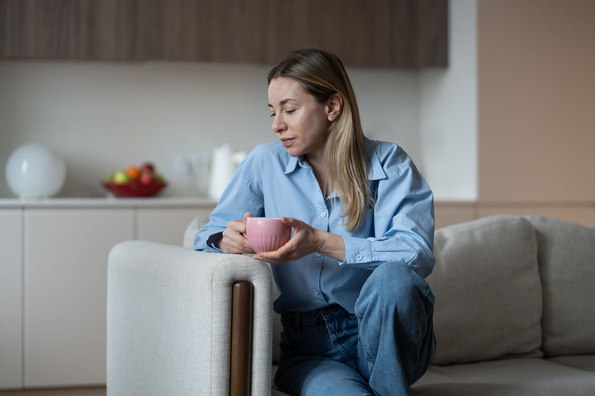 donna over 40 rilassata sul divano dopo una cena anti gonfiore e una routine serale leggera