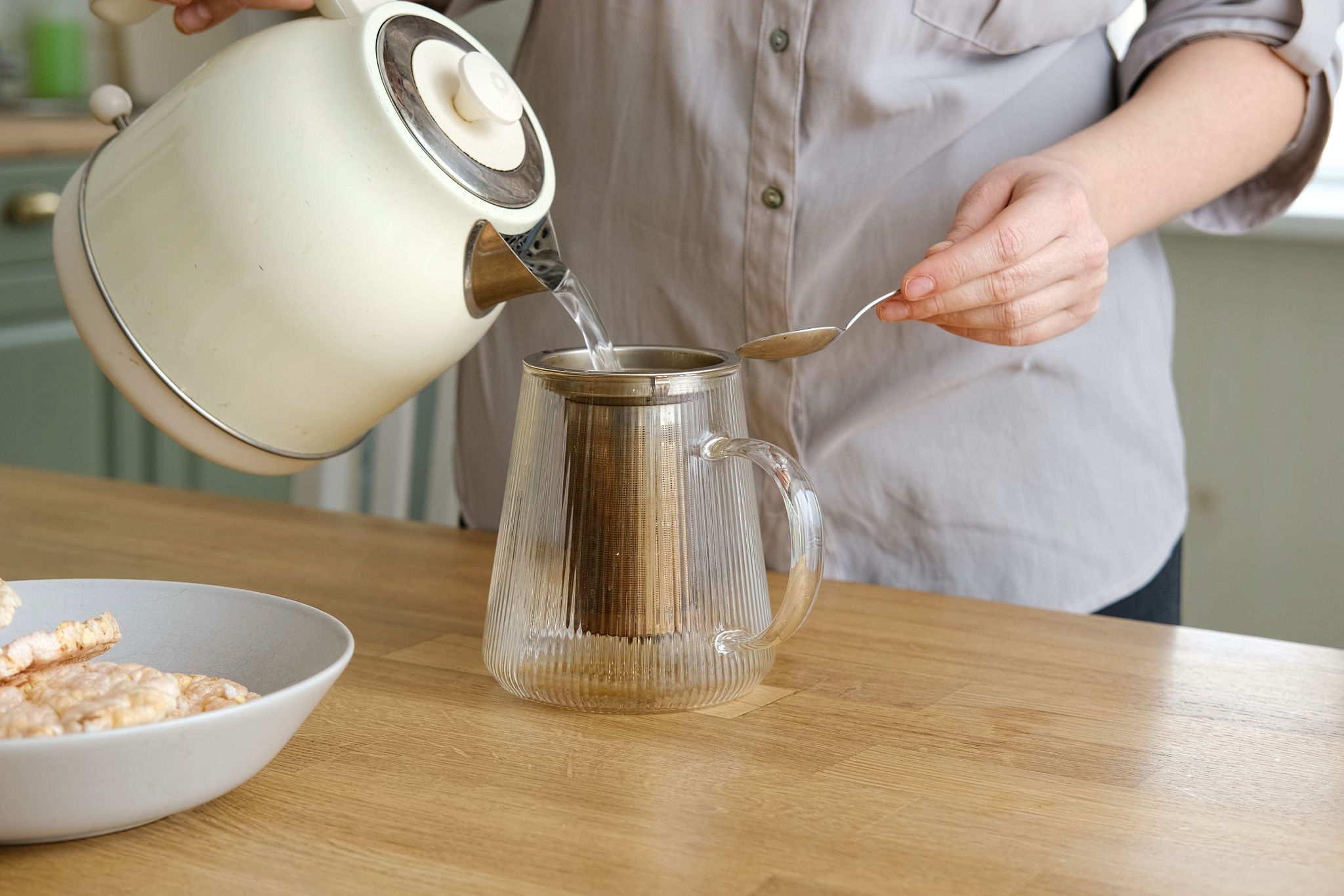 donna che prepara una tisana mattutina come routine anti gonfiore per migliorare la digestione