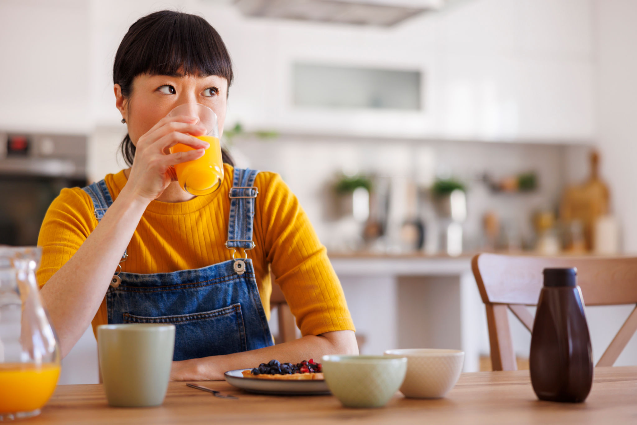donna over 40 che beve una spremuta a colazione che può causare gonfiore addominale