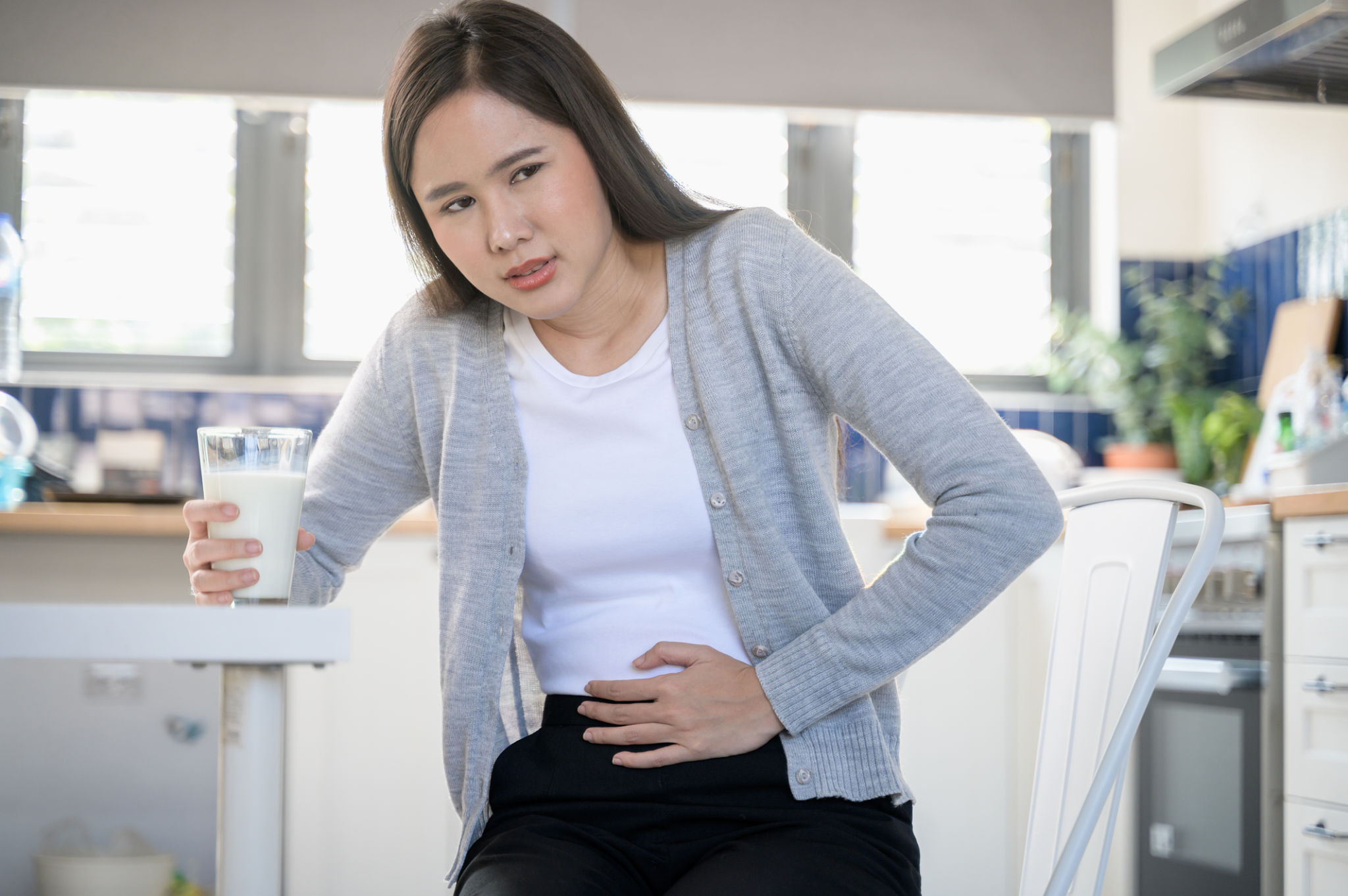 cappuccino pancia gonfia con donna che tiene la pancia dopo aver bevuto cappuccino al mattino