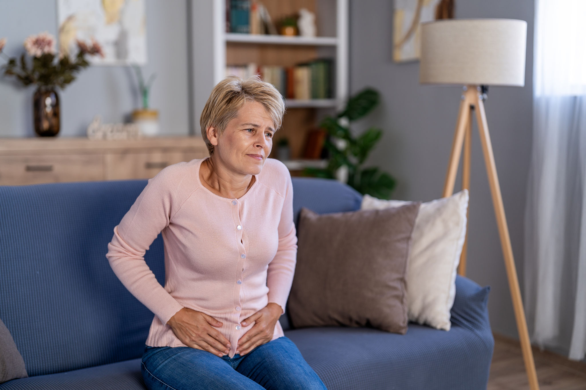 gonfiore in menopausa con pancia gonfia anche se mangi poco in donna adulta seduta sul divano