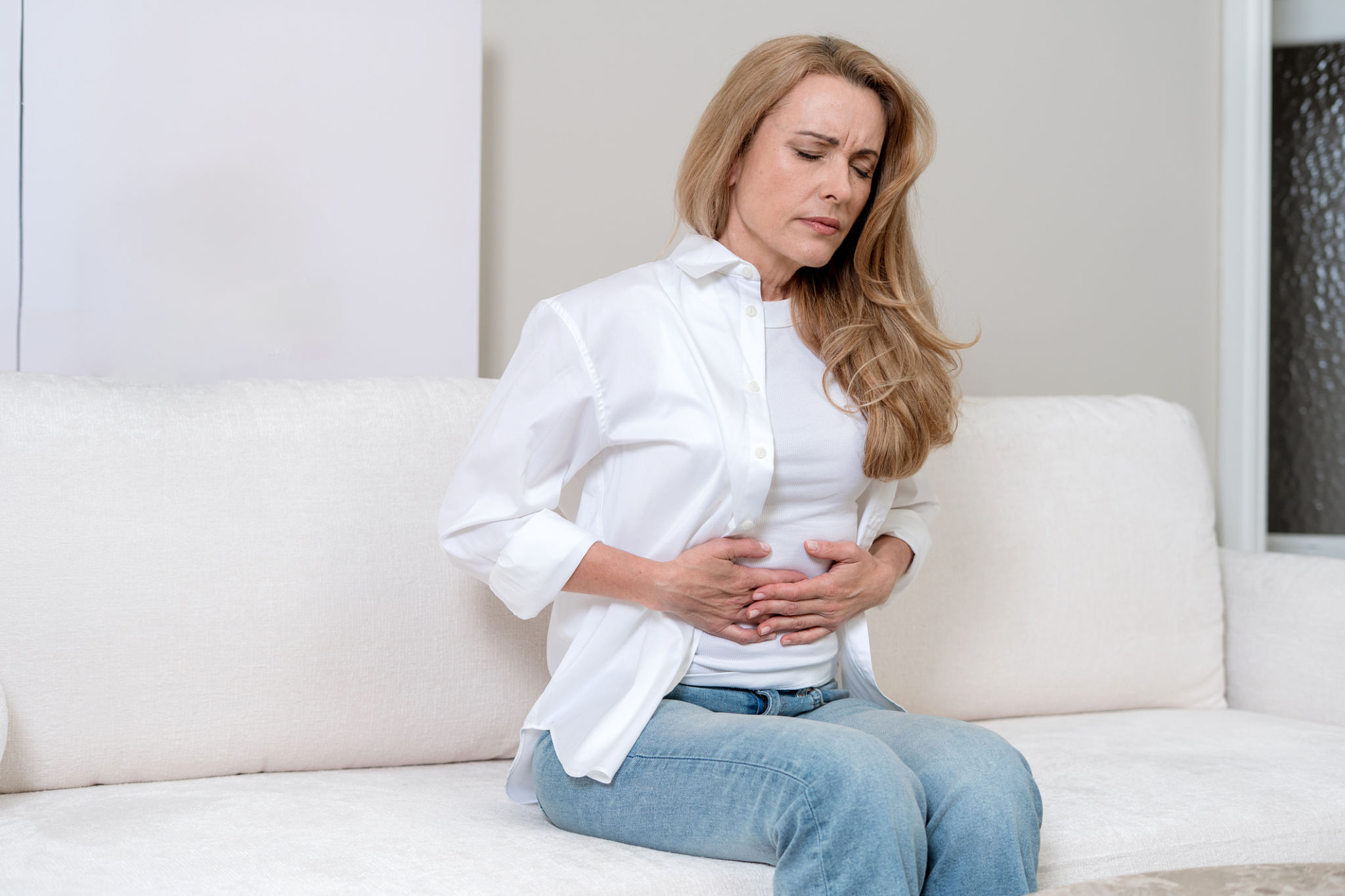 pancia gonfia al mattino con mani sull’addome in donna adulta al risveglio