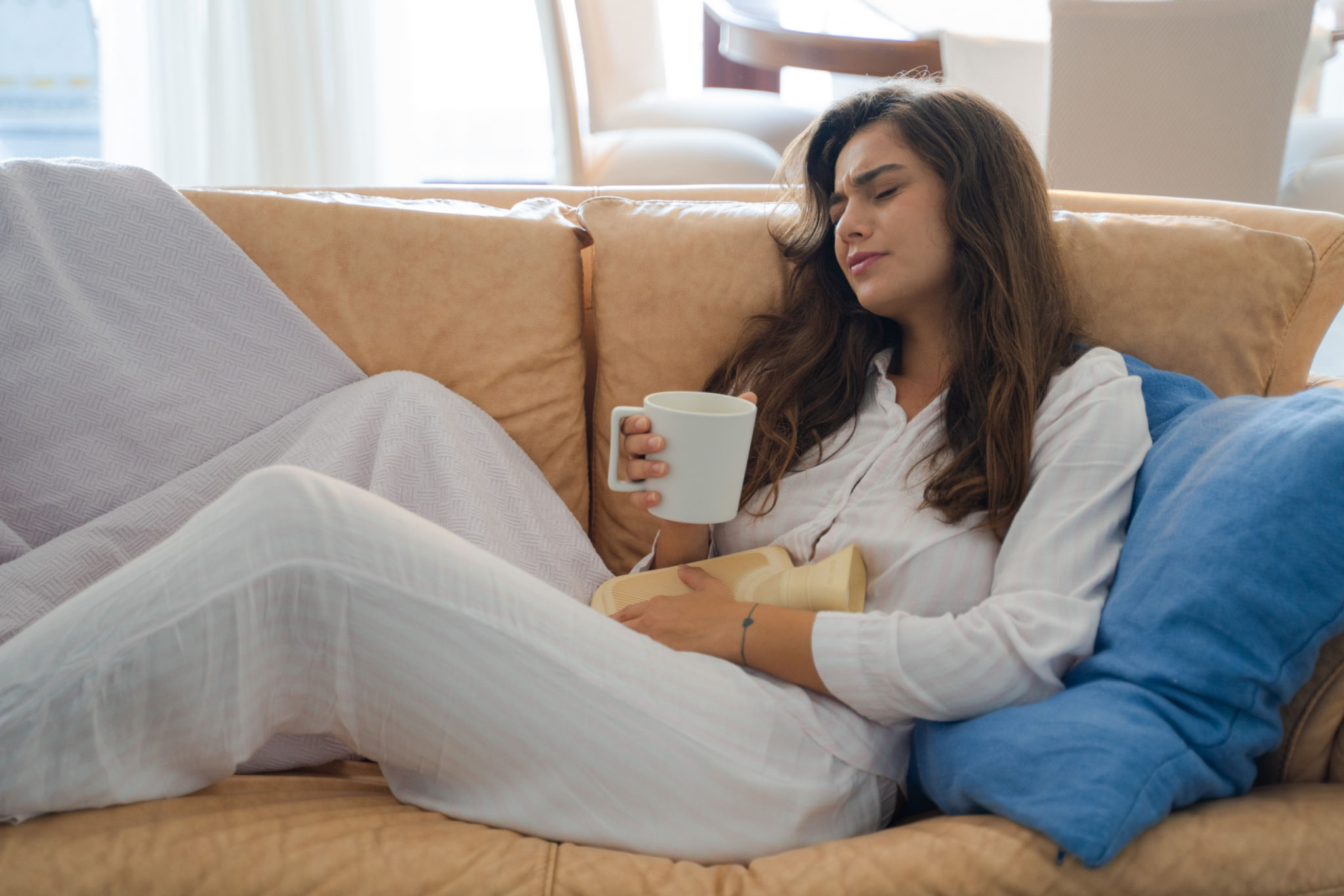 smettere il caffè e gonfiore con donna over 40 che osserva la pancia al mattino