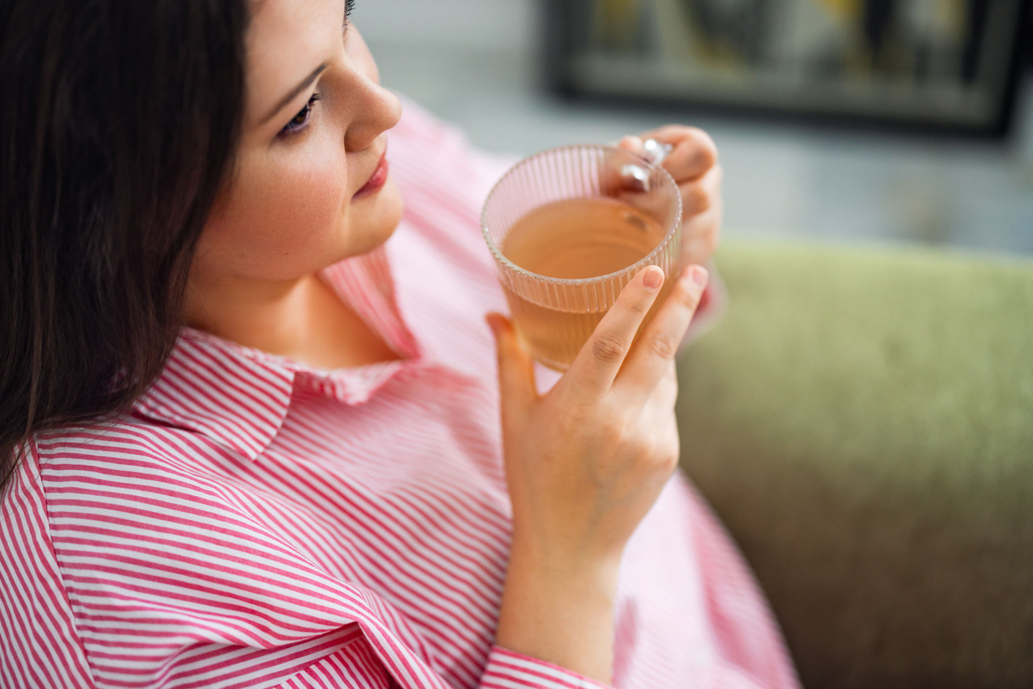 tisana sgonfia pancia mattina o sera con donna che beve tisana e avverte pancia gonfia