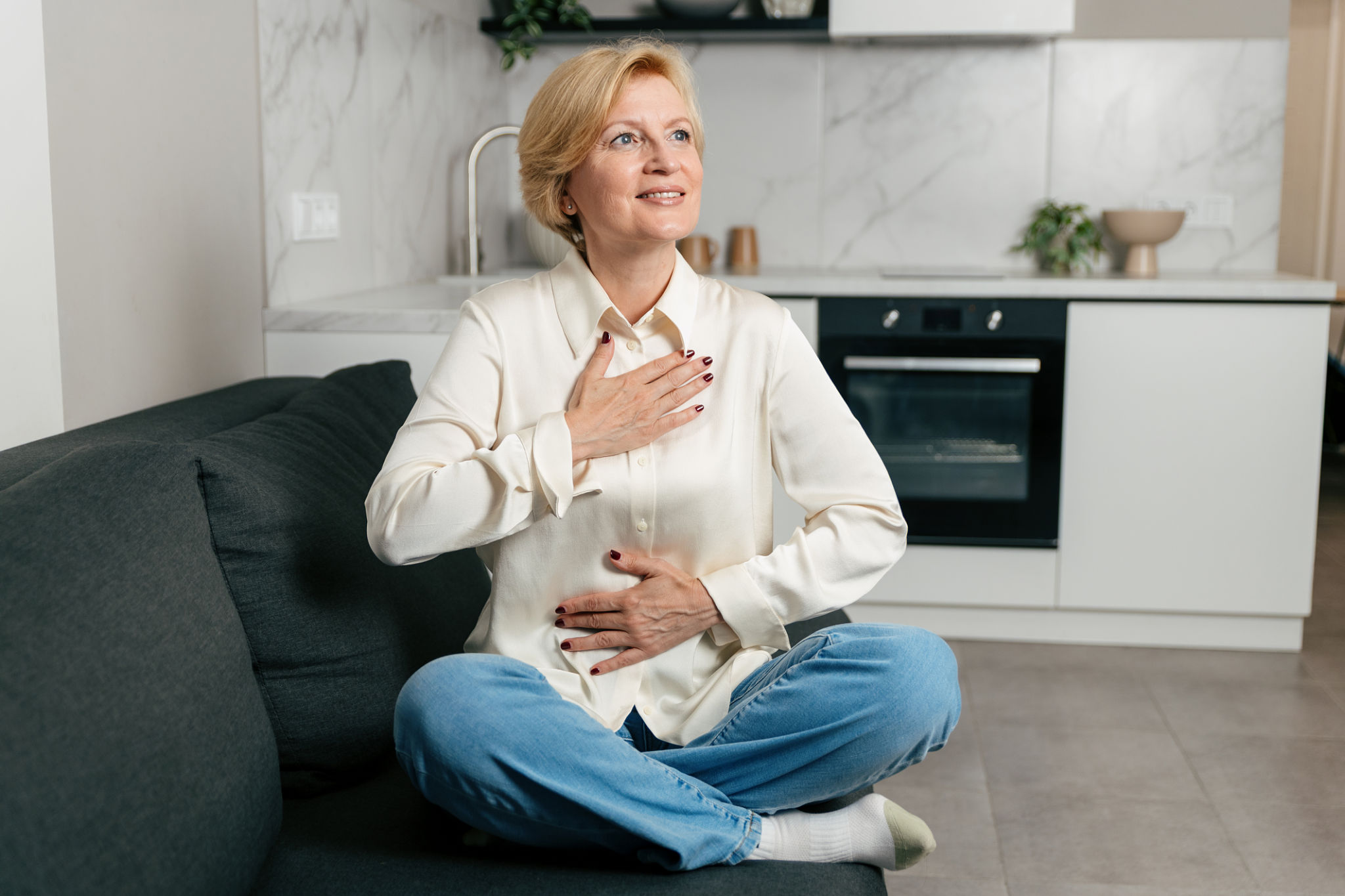 pancia gonfia in menopausa cosa fare donna seduta con mani sull addome